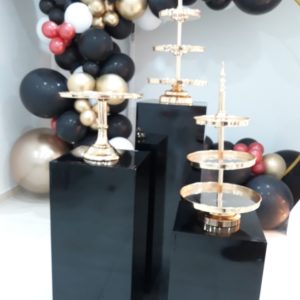 Gold cake stands on black plinths